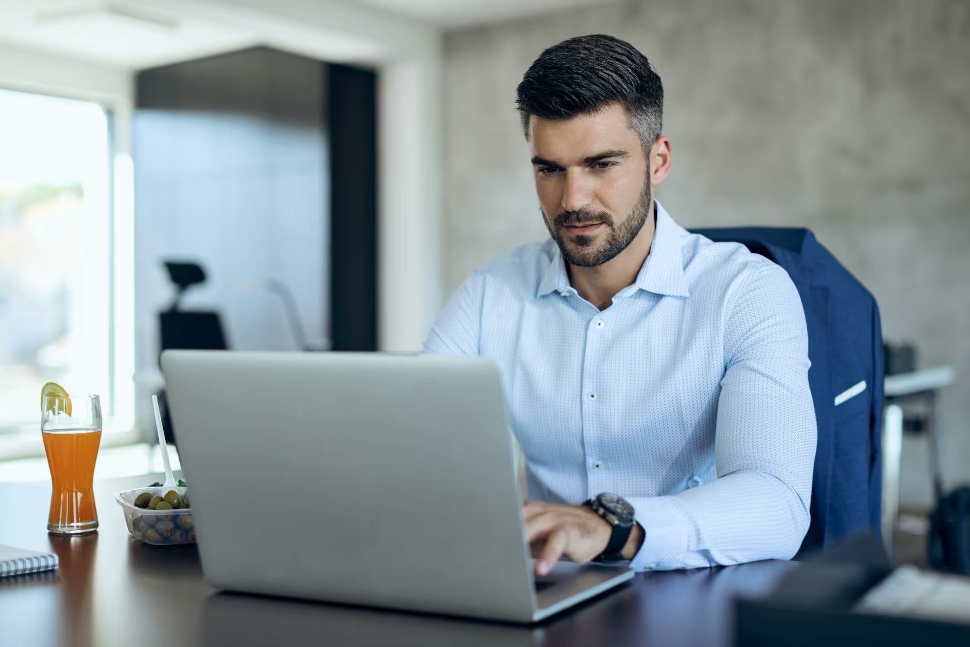 Man sitting at a computer working on bookkeeping tasks.